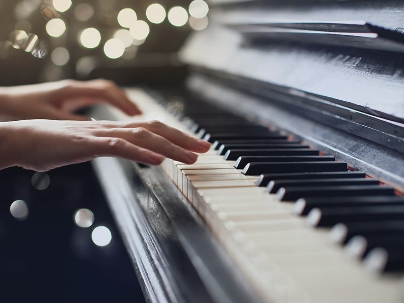 Hands playing piano keyboard