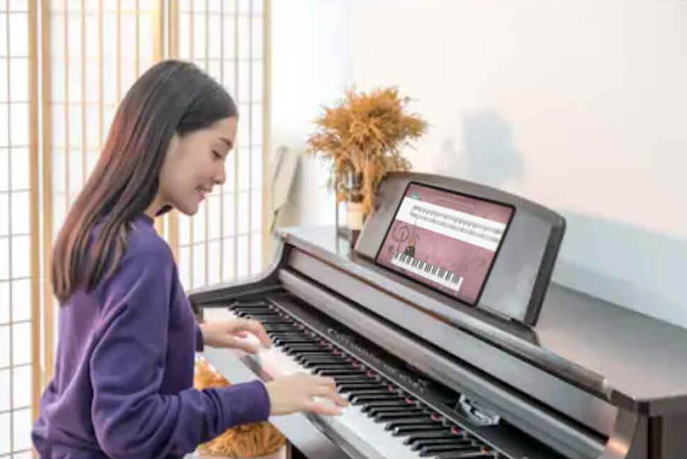 Girl at digital piano with iPad learning piano